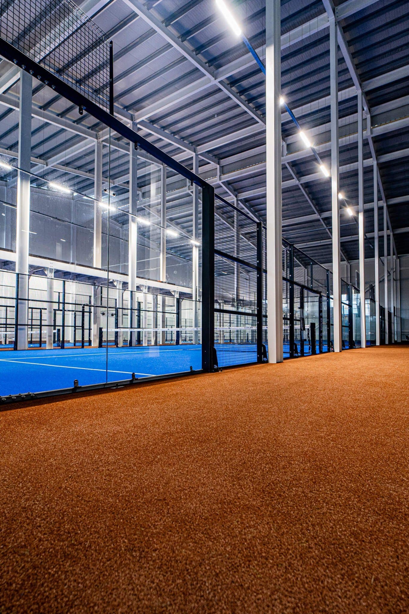 Surrounding surface and steel columns around an Evolve padel court