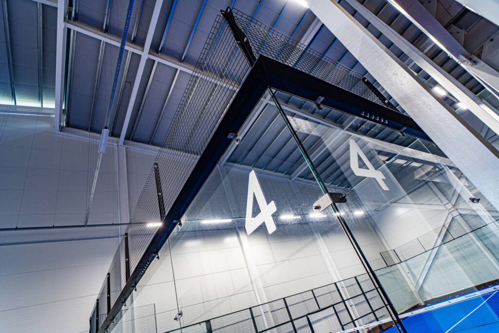 Stainless steel glass fixings on the structure of an Evolve padel court